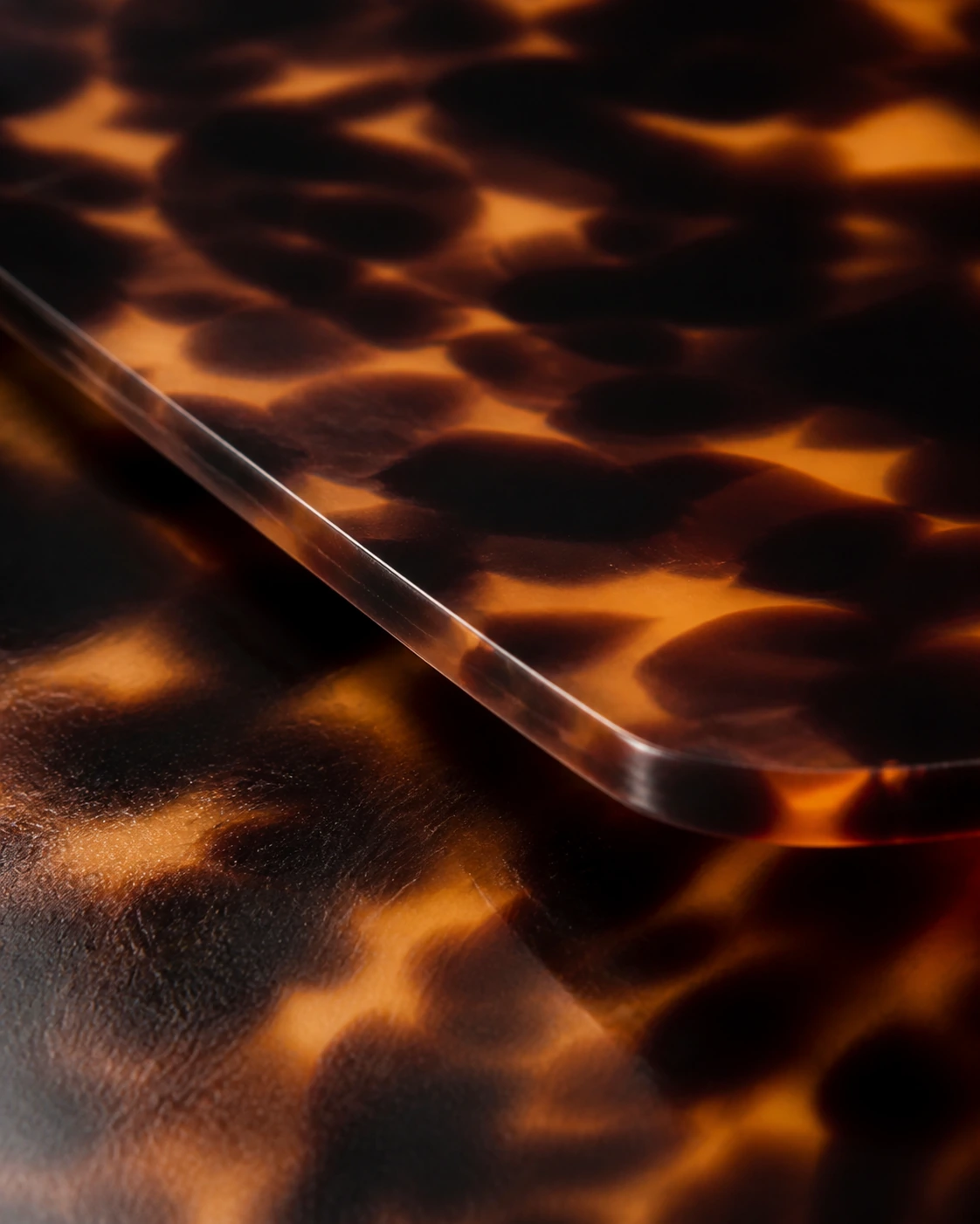 Macro of dark tortoise acetate with a polished bevelled edge.