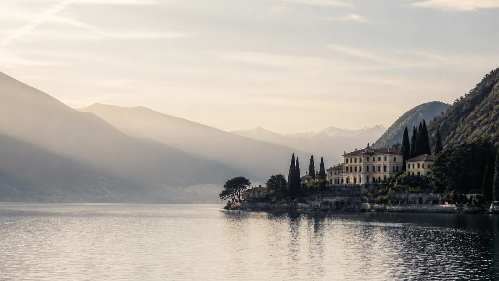 Lake Como at dawn: mist over the water, a villa among cypresses.